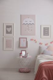 Stylish child's room interior with beautiful pictures and comfortable bed