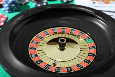 Photo of Roulette wheel with ball on table, closeup. Casino game