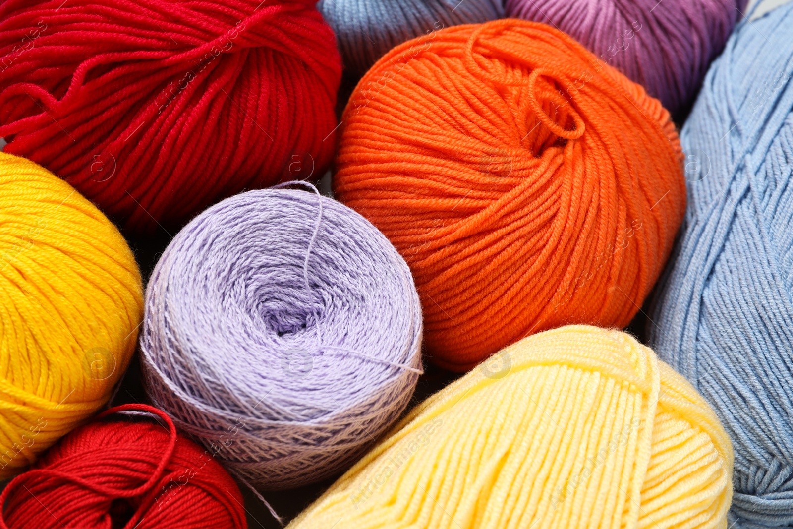 Photo of Different colorful woolen yarns as background, closeup