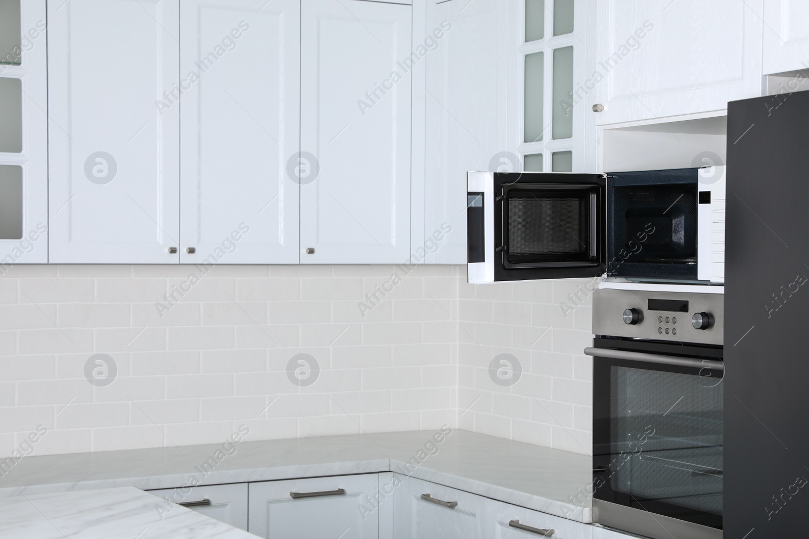 Photo of Modern oven and microwave in white clean kitchen