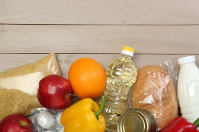 Photo of Different donation food on wooden table, flat lay. Space for text