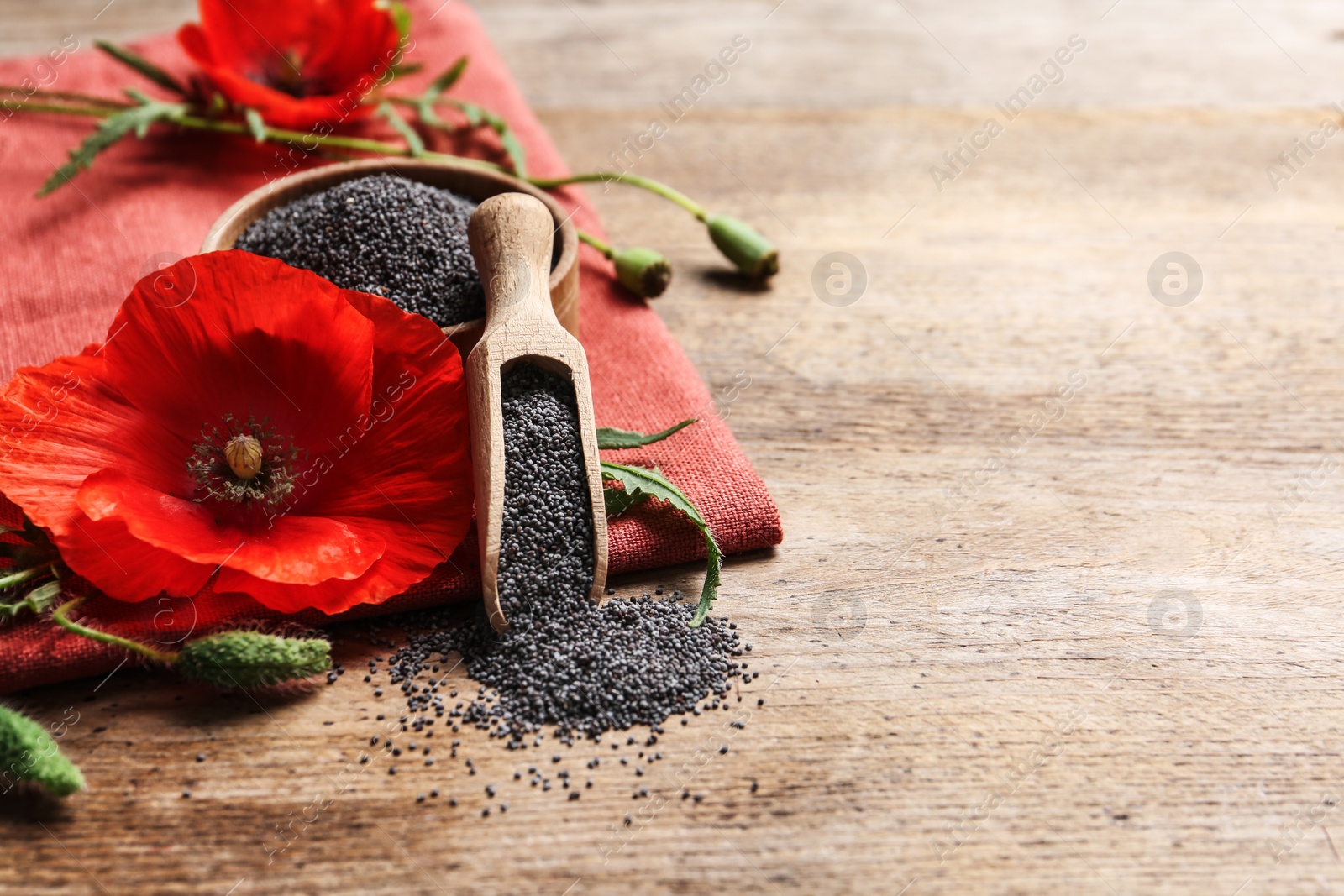 Photo of Composition with poppy seeds and flower on wooden table, space for text
