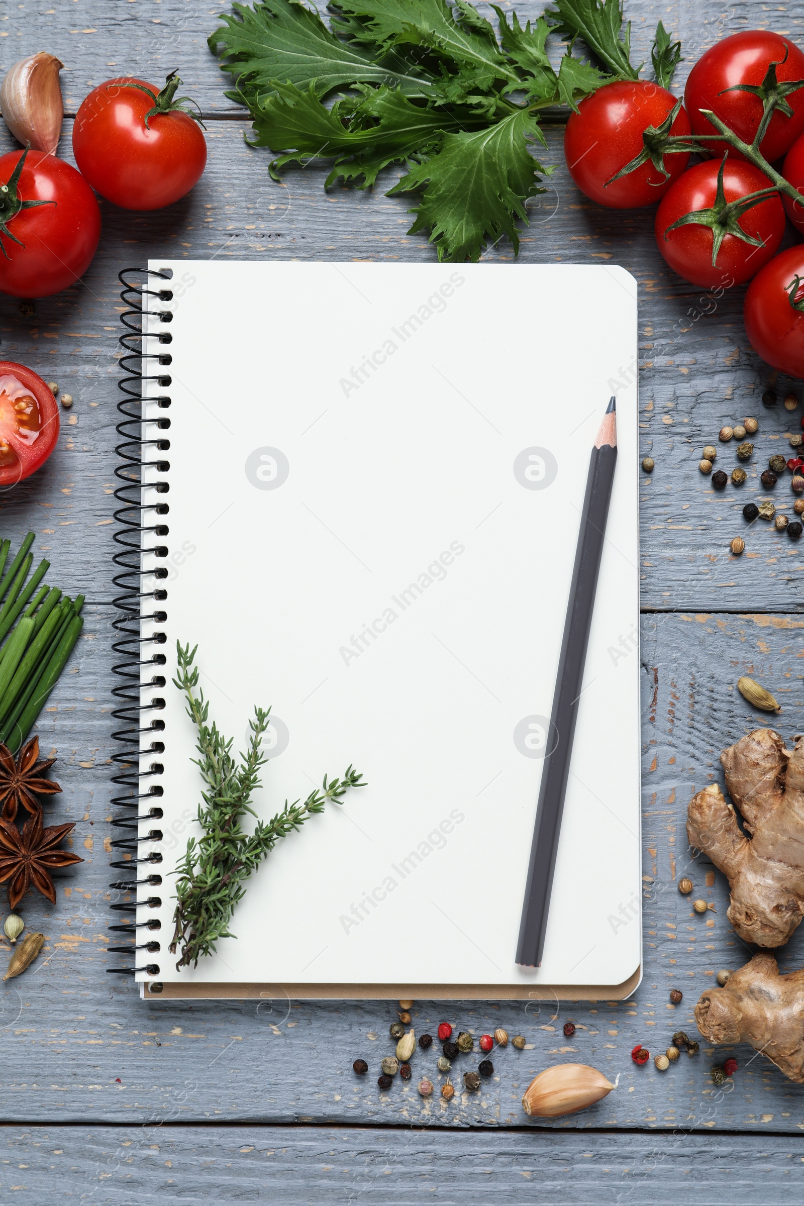 Photo of Open recipe book and fresh products on grey wooden table, flat lay. Space for text