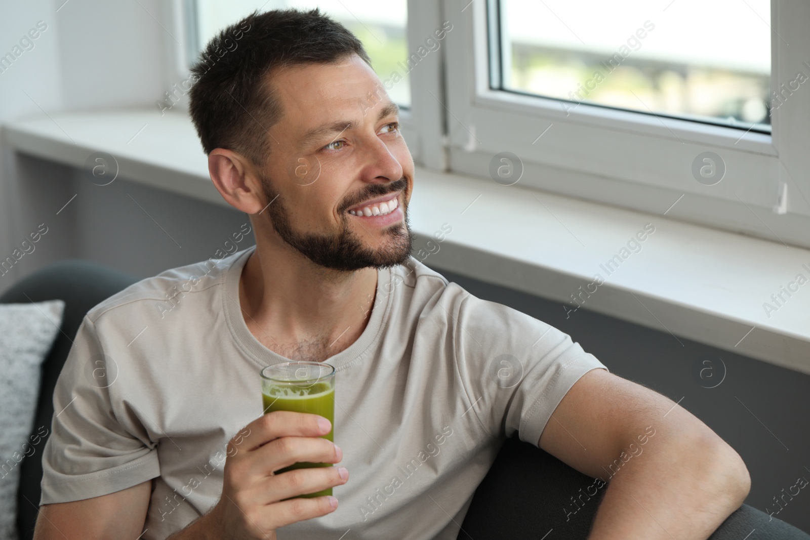 Photo of Man holding glass of delicious juice at home