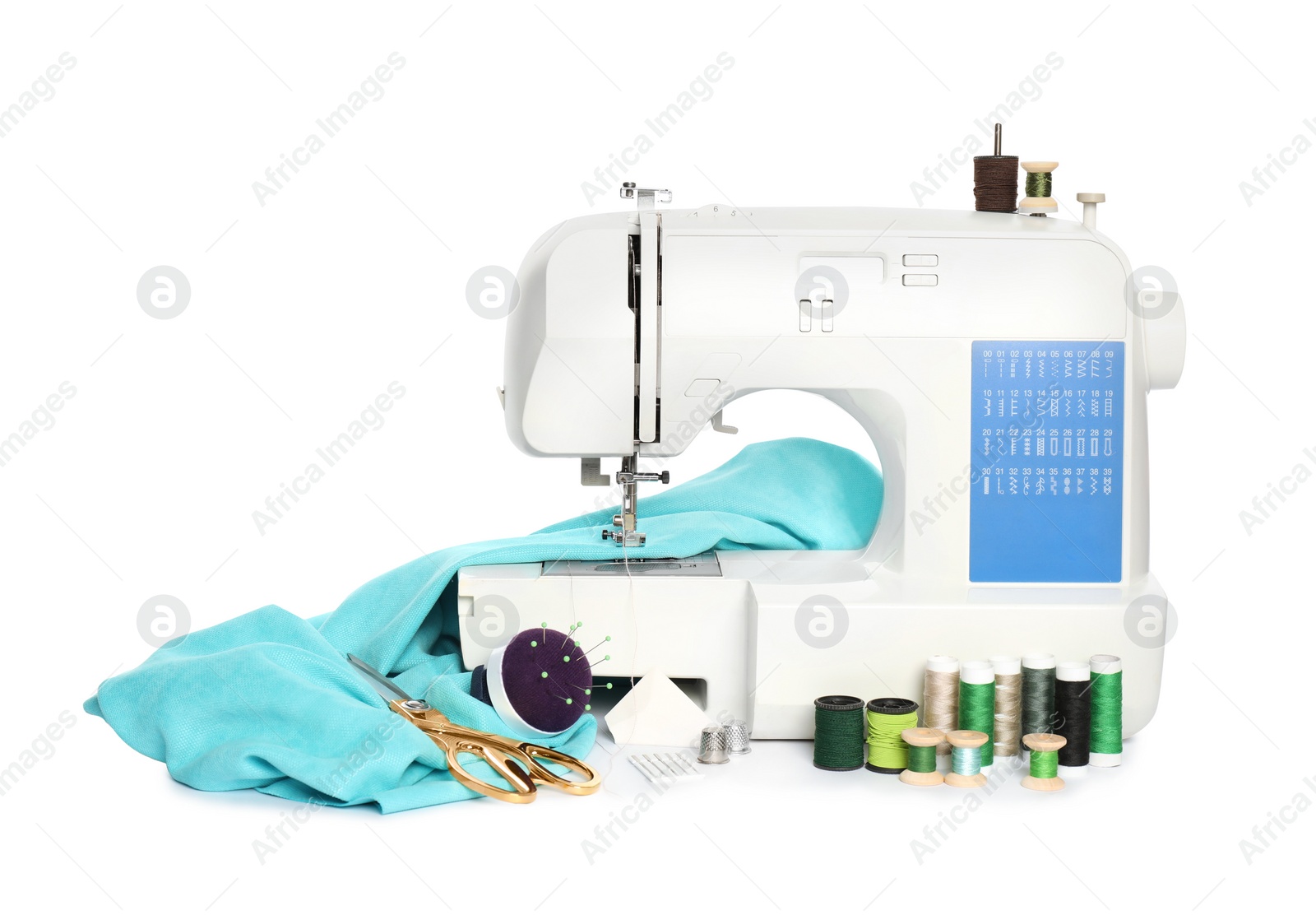 Photo of Modern sewing machine with light blue cloth and craft accessories isolated on white