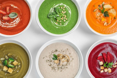 Various soups in bowls on white background, top view. Healthy food