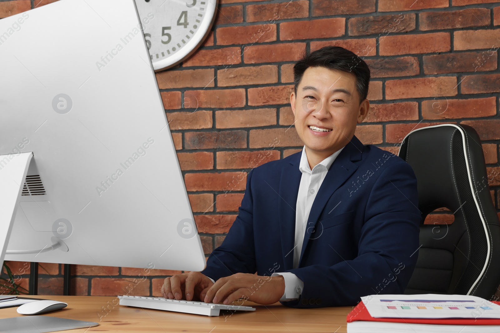 Photo of Happy boss working in his modern office