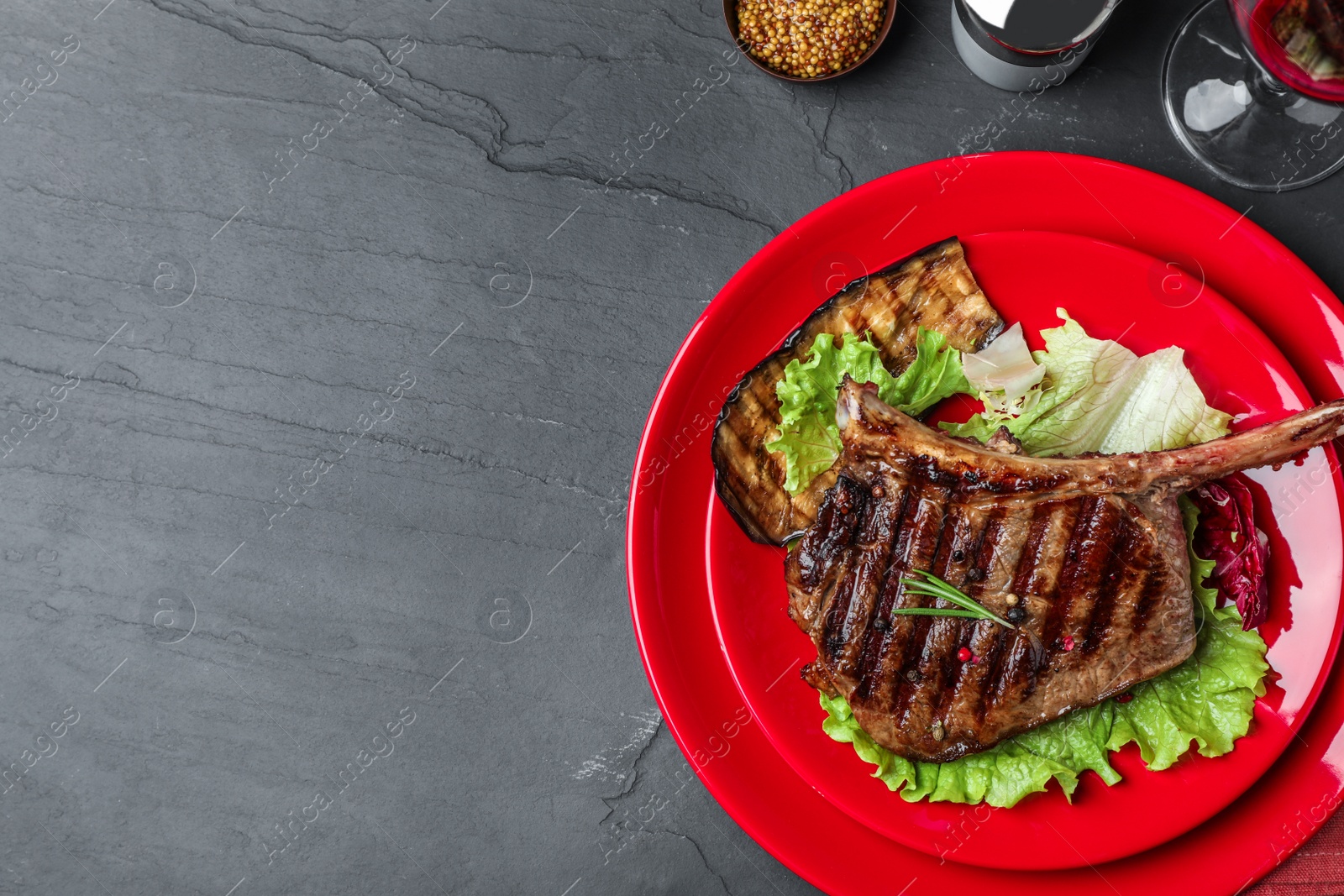 Photo of Delicious beef steak served on grey table, flat lay. Space for text