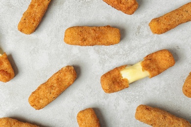 Photo of Tasty cheese sticks on grey background, top view