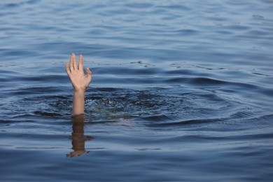 Drowning woman reaching for help in sea, closeup