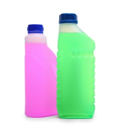 Plastic canisters with different liquids for car on white background