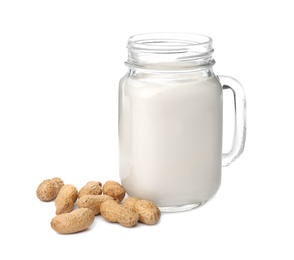 Photo of Mason jar with peanut milk and nuts on white background