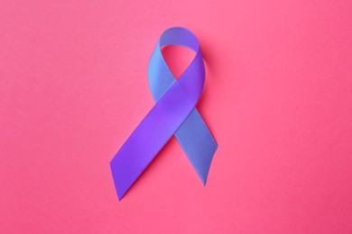 Image of World Arthritis Day. Blue and purple awareness ribbon on pink background, top view