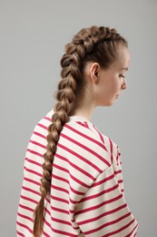 Woman with braided hair on grey background