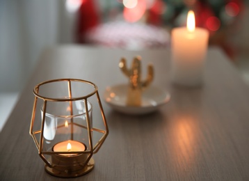 Burning candle in elegant holder on table