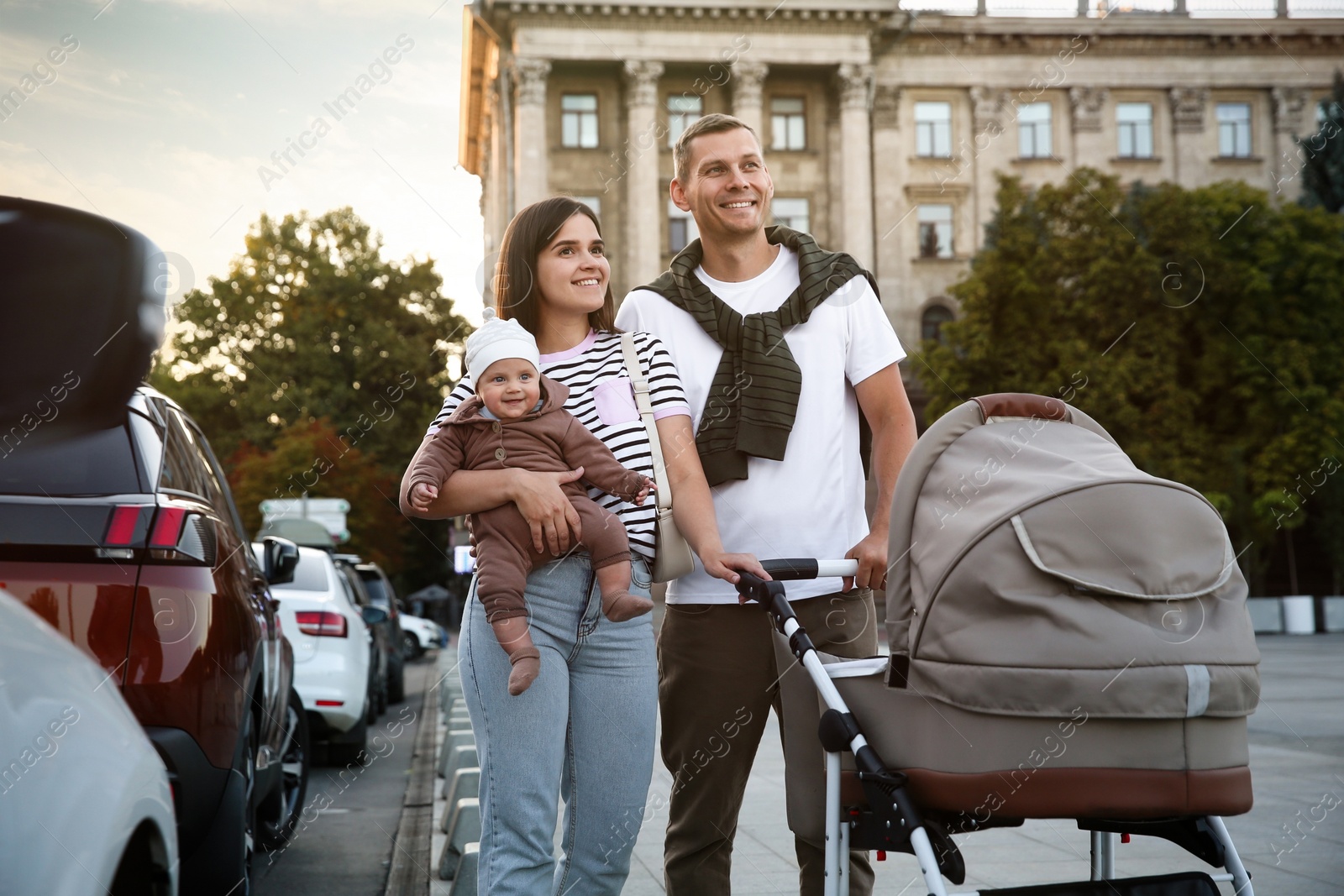 Photo of Happy parents walking with their baby outdoors