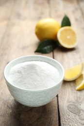 Photo of Baking soda and cut lemons on wooden table