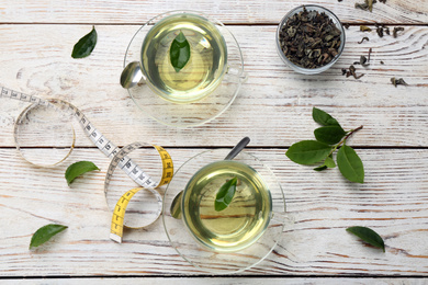 Flat lay composition with diet herbal tea on white wooden background