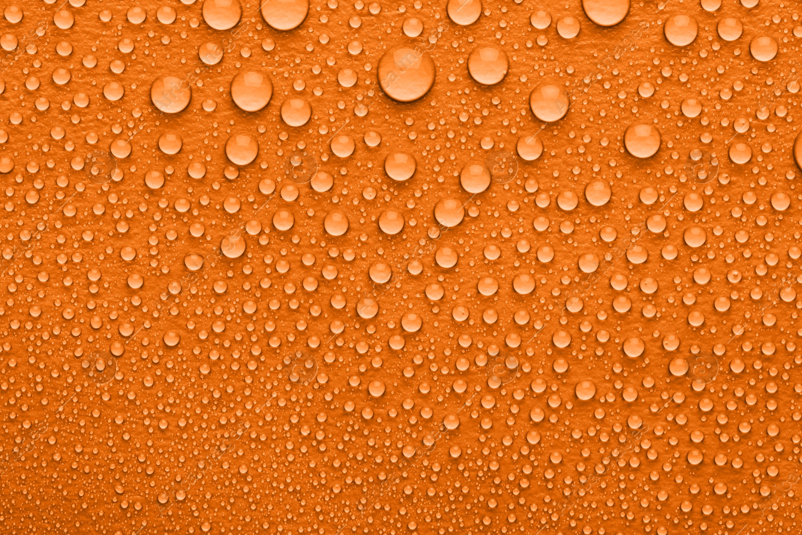 Image of Water drops on orange background, top view