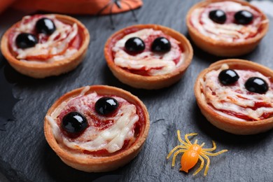 Cute monster tartlets served on slate plate, closeup. Halloween party food