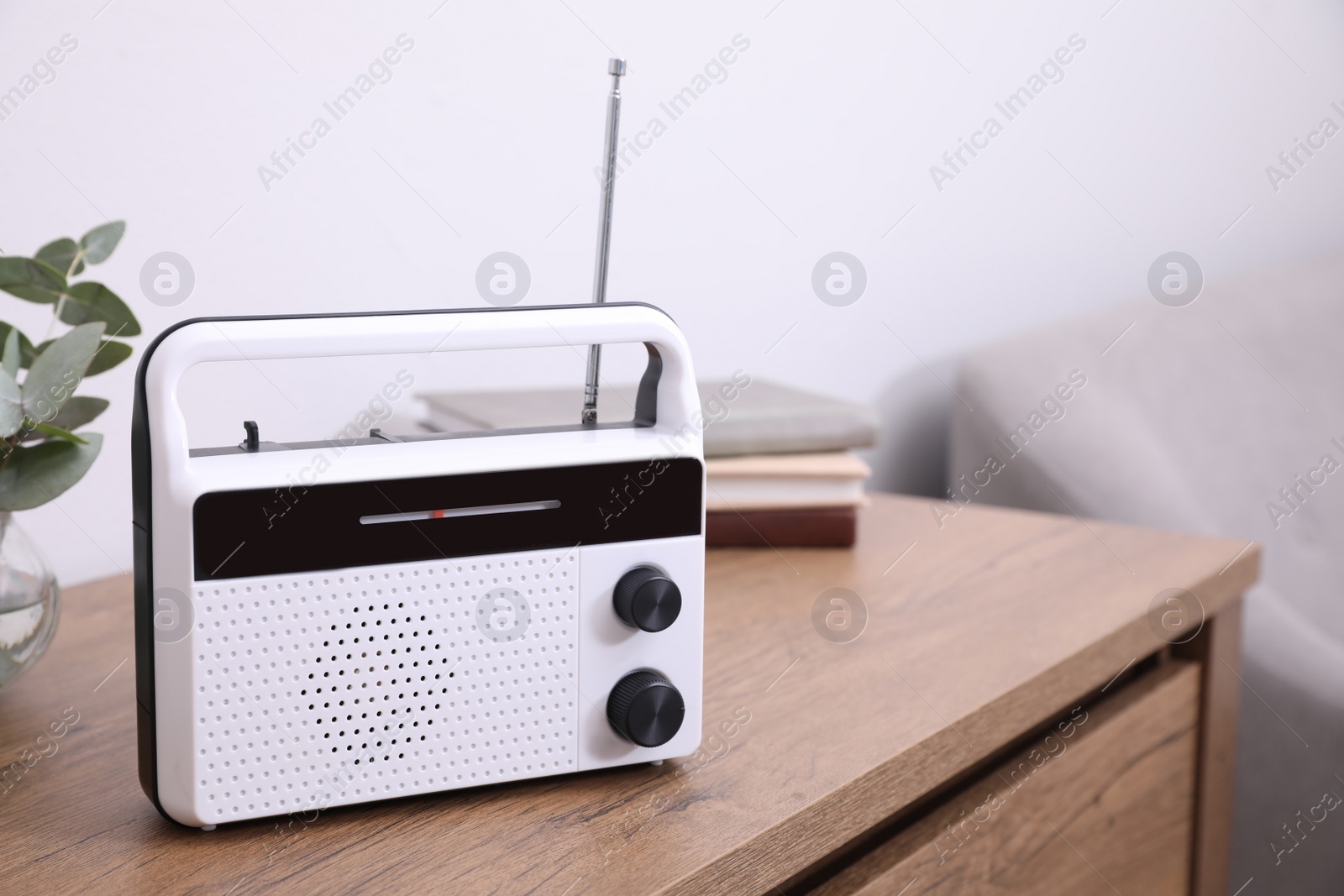 Photo of Stylish white radio on wooden table indoors. Space for text