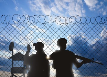 Silhouettes of border guards at post outdoors in early morning