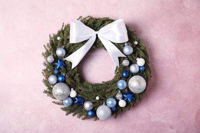 Beautiful Christmas wreath on light pink wall