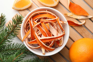 Photo of Dry peels, oranges and fir branch on white table, flat lay