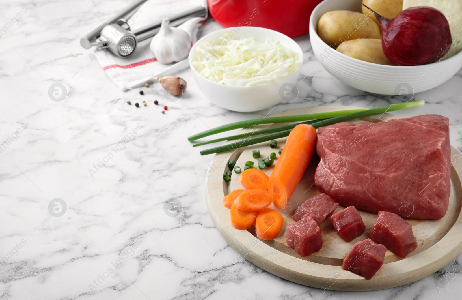 Photo of Fresh borscht ingredients on white marble table, space for text