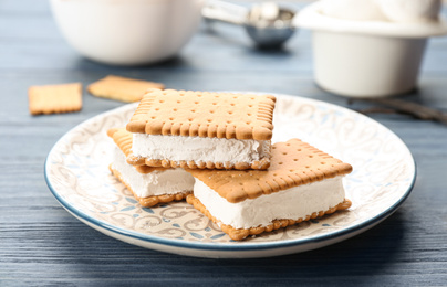 Photo of Sweet delicious ice cream cookie sandwiches on blue wooden table