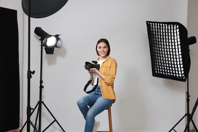 Professional photographer with camera in modern photo studio