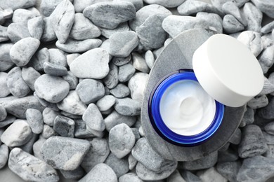 Jar of moisturizing cream on stones, top view. Space for text