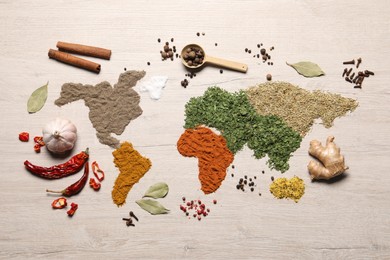 Photo of World map of different spices and products on wooden table, flat lay