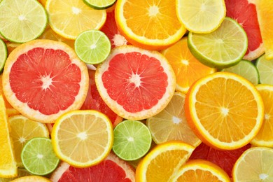 Different citrus fruits as background, top view