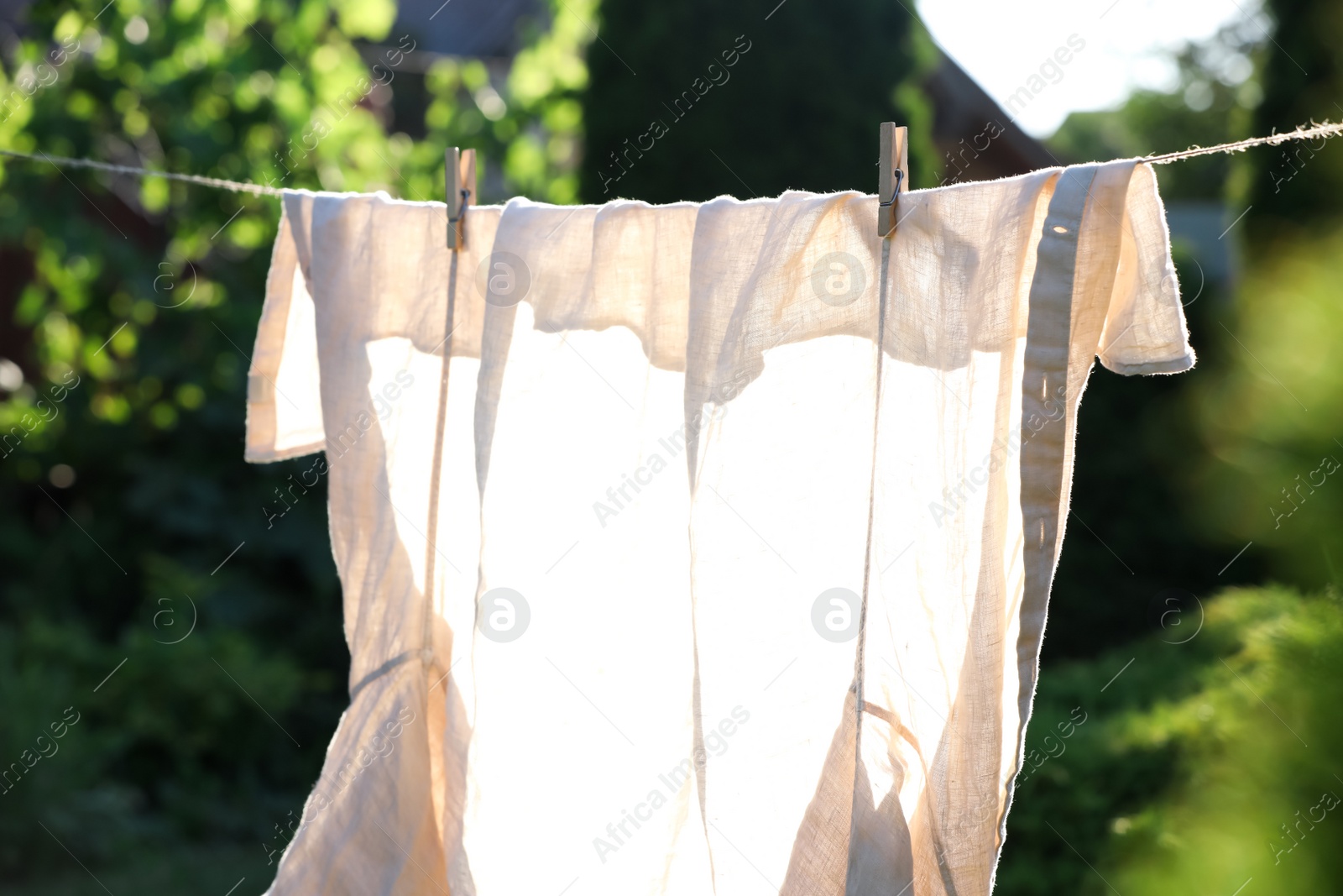 Photo of Shirt drying on washing line against blurred background, closeup