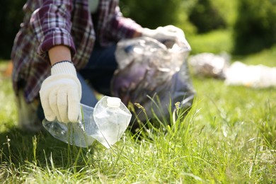 Woman with plastic bags collecting garbage in park