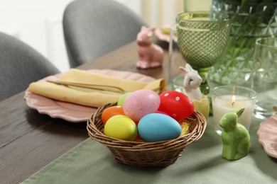 Photo of Festive Easter table setting with painted eggs, closeup