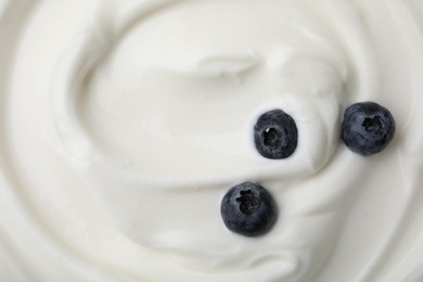 Tasty yogurt with blueberries as background, top view. Space for text