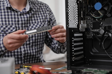 Male technician repairing computer at table, closeup