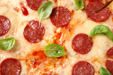 Photo of Hot delicious pepperoni pizza with melted cheese, closeup