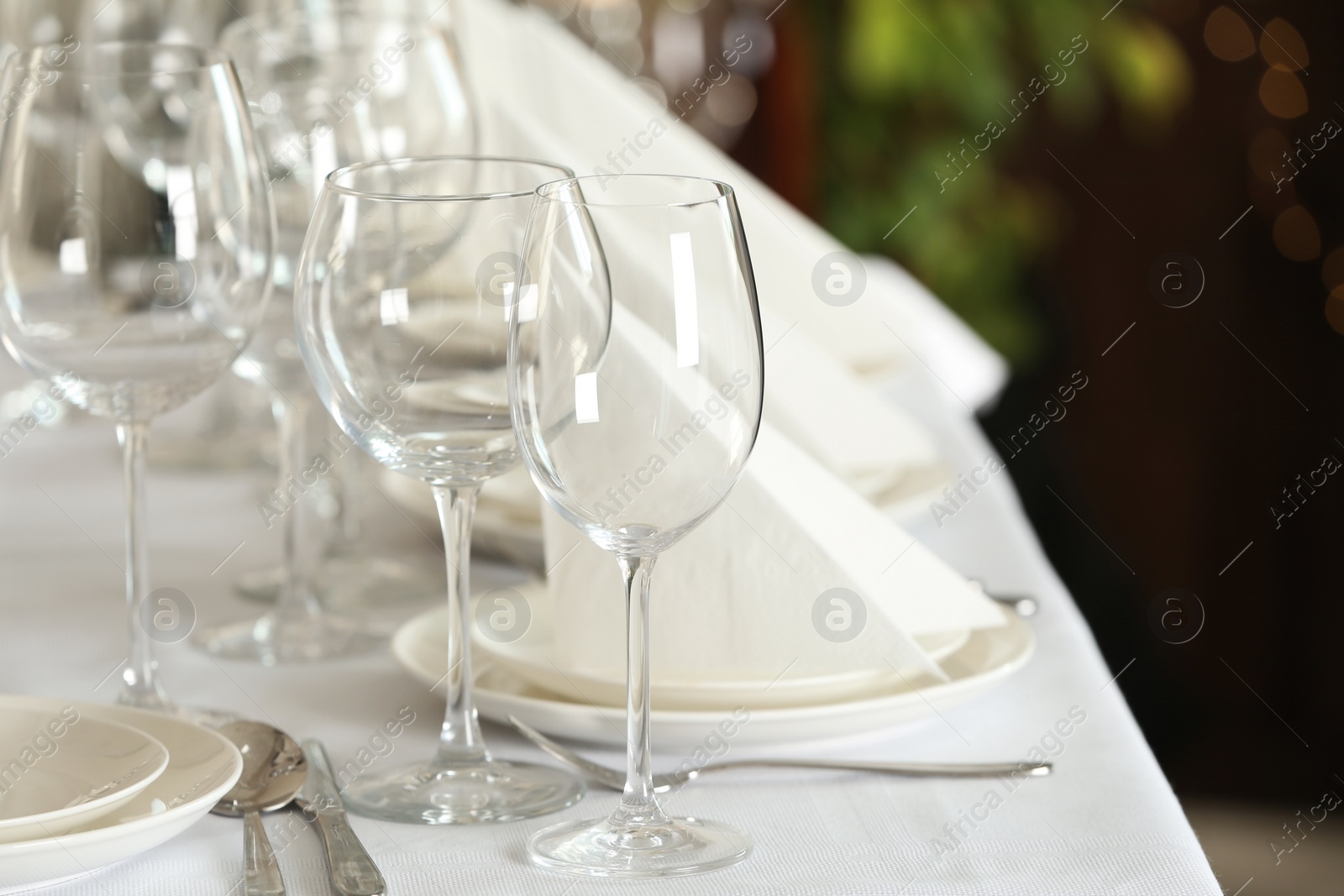 Photo of Table setting with empty glasses, plates and cutlery indoors