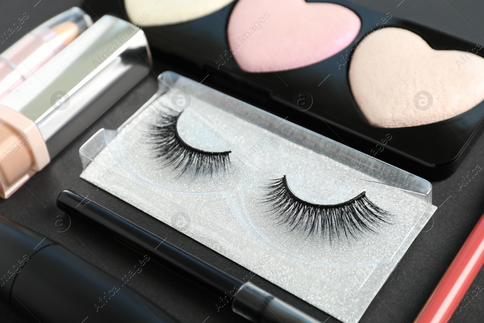 Photo of Set of makeup products on dark background, closeup