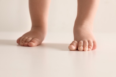 Photo of Little baby on light background, closeup on feet