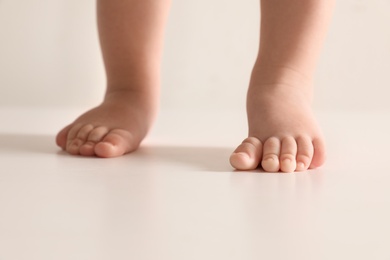 Little baby on light background, closeup on feet