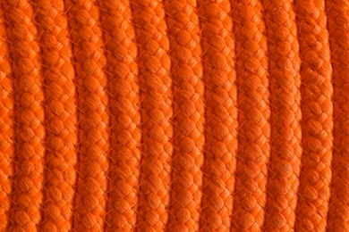 Photo of Texture of orange wicker mat as background, top view