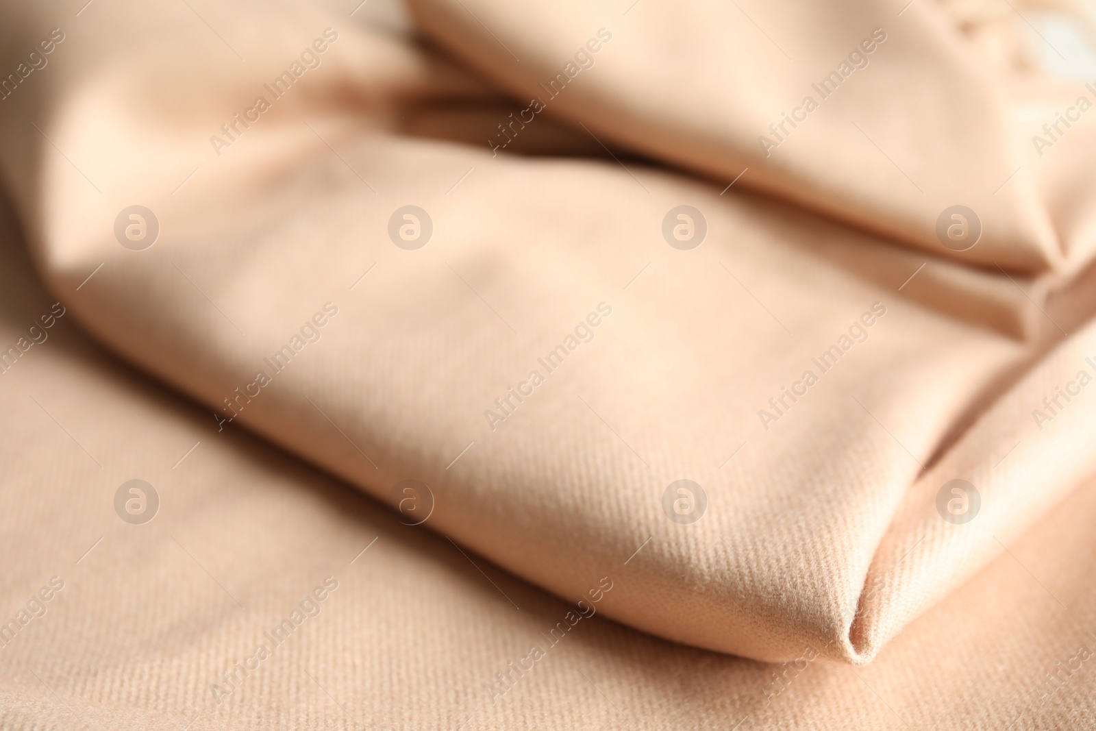 Photo of Beige soft cashmere fabric as background, closeup