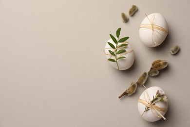 Photo of Festively decorated chicken eggs on light grey background, flat lay with space for text. Happy Easter