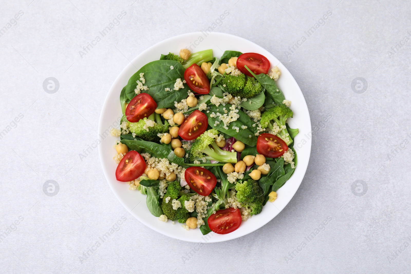 Photo of Healthy meal. Tasty salad with quinoa, chickpeas and vegetables on light grey table, top view