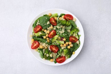 Healthy meal. Tasty salad with quinoa, chickpeas and vegetables on light grey table, top view