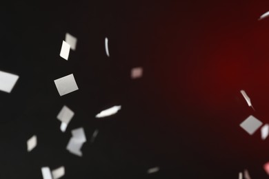 Photo of White confetti falling down, toned in red